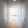 淡いグレーで統一された、全体的に光を絞ったトンネルのような廊下