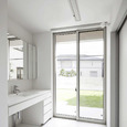 中庭を見ながら身支度ができる、明るく開放的な白一色の洗面脱衣室