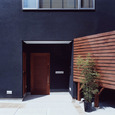 黒い壁に木目が映える玄関アプローチ