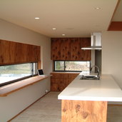 木板の風合いを生かした明るいオープンキッチン