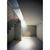 トップライトの光が降り注ぐコンクリート壁のリビング