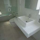 ニュアンスのあるタイル張りが白い空間にアクセントとなり落ち着いた雰囲気のバスルーム