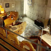 ワインバーの店内は丸太の荒削りのベンチやカウンターテーブルなどラフで力強いインテリア