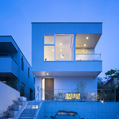 夕景に室内の光が優しく溢れる外観