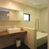 目地の少ないすっきりとした印象を与える、大きめのタイルを用いた洗面所・浴室