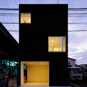 夜の光が黒い外壁を柔らかな印象に変える外観