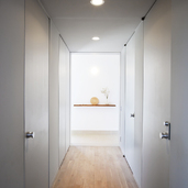 淡いグレーで統一された、全体的に光を絞ったトンネルのような廊下