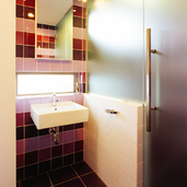 パープルのタイルが印象的な洗面スペース