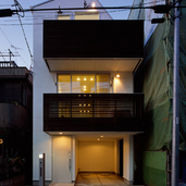 ルーバーの隙間から見えるぼんやりと灯される光が魅力的な夜の外観