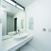 トップライトからの光と壁一面の鏡が、洗面所を広く見せる手段の一つ