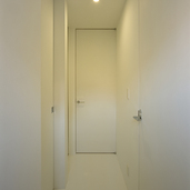 天井高まであるそれぞれの扉が、縦長の空間作りに役だっている廊下