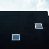 真っ黒な壁面に、小さなスクエア窓がかわいらしく配置する