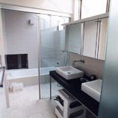 Ｌ字のトップライトが、大きめの床壁タイルに燦々と光を注ぐ洗面・浴室