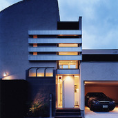 吹き抜け空間に美しく光る室内光が、プライバシーを守りつつ大胆に光放つ外観