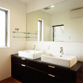 横長に大きな一枚鏡と洗面ボールを２つ設置した、２世帯住宅でも混雑がない広い洗面所