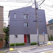 赤いドアが差し色の外観