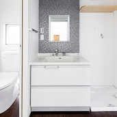 白い空間にグレーのタイルがモダンな雰囲気を醸し出す洗面・トイレ