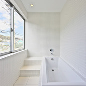 大きな窓のあるタイル張りの明るいバスルーム