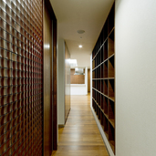 収納や、タイル張りの壁仕上げ材の色を合わせ、重厚感を演出した廊下