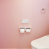 淡いピンクの壁紙が可愛らしいトイレ
