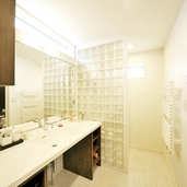 大きな鏡とガラスブロックでゆったりとした印象に