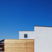 モルタル下地吹付塗装の継ぎ目のない外壁とレッドシダーの目隠し塀