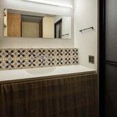 洗面室にもお施主様が調達したタイルをレイアウト。2人同時使用できる間口を確保。水栓はレトロな2ハンドル。