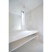 光沢のある白でまとめた洗面室