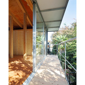 木漏れ日の注ぐ庇に覆われた木製のバルコニー