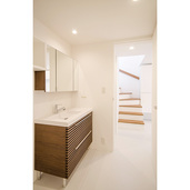 白い壁と調和した木目の洗面