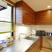 赤みの強いアメリカンチェリーの木目が珪藻土の柔らかい色味の壁や天井のアクセントに