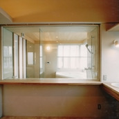 バスルームのガラス張りから明るい光が差し込む洗面スペース