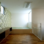 壁の一面をアクセントにし、フリースペースとしてタタミを置いたリビング