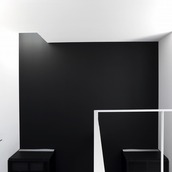 黒と白の壁に当たる光が、壁に立体的な表情を与える吹抜け