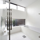 中庭を楽しみながらのんびりと入浴できる、天井高のある広々とした浴室