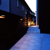 外壁の焼杉の素材感、玄関ホールまで続く柔らかい光が、日本の美を感じるアプローチ