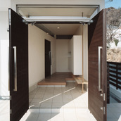 観音開きに開く玄関ドアと、縁側のように癒される広さのある玄関ホール