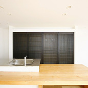 格子戸の収納扉を備えたモダンなキッチン