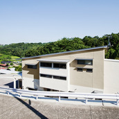 道路の勾配に屋根や窓を合わせた外観