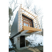 地階の玄関アプローチから上部の建物を見上げる