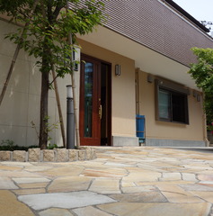 無造作のタイルと緑のある玄関ポーチ