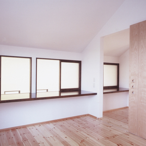 食欲を増す朱色の壁面が、焦げ茶色でまとめた空間にインパクトを与えるキッチン