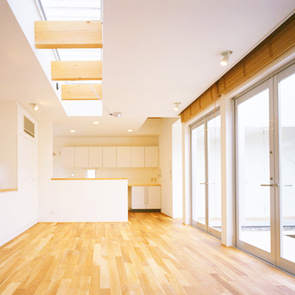 ソファーの背面の壁をガラス越しに玄関ホールまで続けることで、視覚的な広がりを感じられるリビング