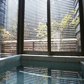 格子戸で仕切られたリビングの一角のベッドコーナー