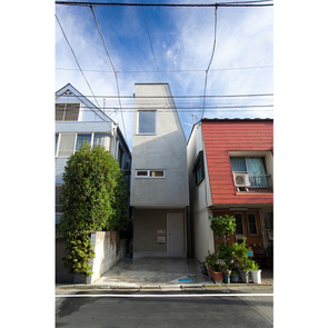 茶色のバルコニーがアクセントの白い外観