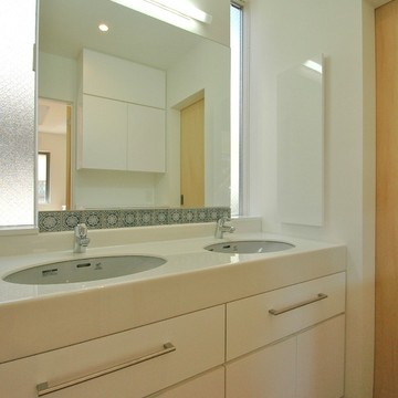 スリット窓からさわやかな陽が射し込むダブルボウルの洗面スペース