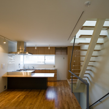 白い空間に床とキッチンの木目が映えるリビングダイニングキッチン