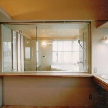 バスルームのガラス張りから明るい光が差し込む洗面スペース