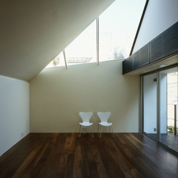 最上階、上部の大きな窓から陽射しを受けるリビング