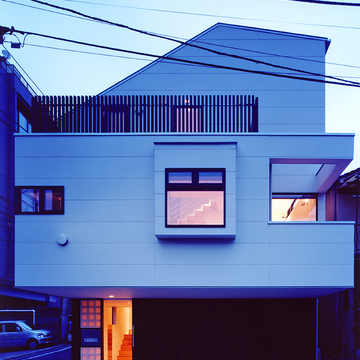 小窓から吹き抜け階段がのぞく夕景外観